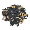 A pile of black and gold foam alphabet letters scattered on a white surface resembles a PEPPER ALPHANUMERIC CUSTOM GRIPTAPE KIT design.