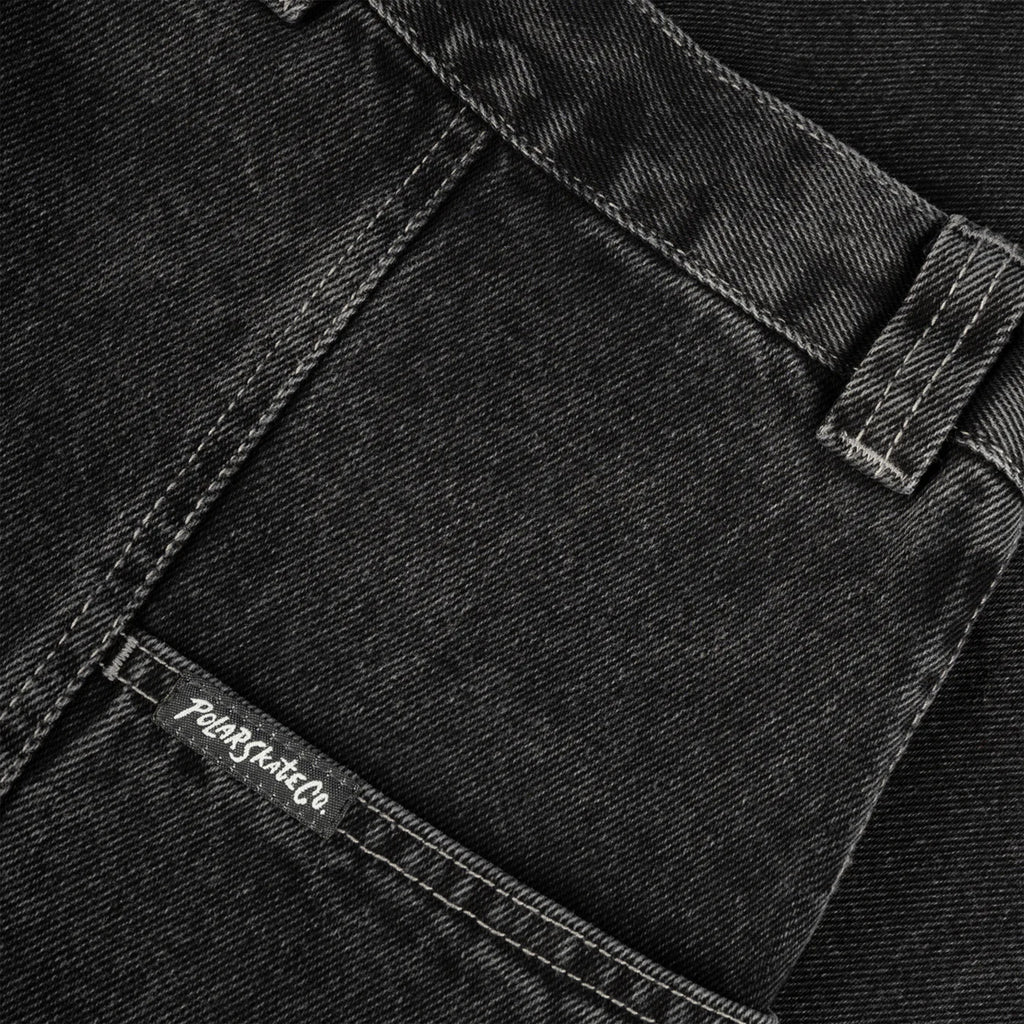 Close-up view of the pocket and belt loop area of black denim jeans, showcasing detailed stitching on the POLAR JIRO PANTS SILVER BLACK and a brand label, "POLAR" on the pocket seam.