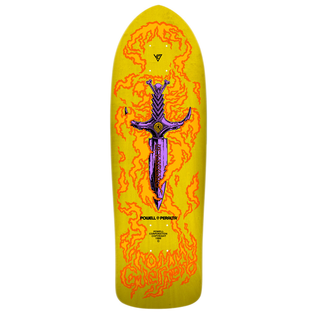A vibrant yellow skateboard deck with an illustrated sword encircled by flames, featuring graphic text elements from the Powell Peralta Bones Brigade Series 15 Guerrero.
