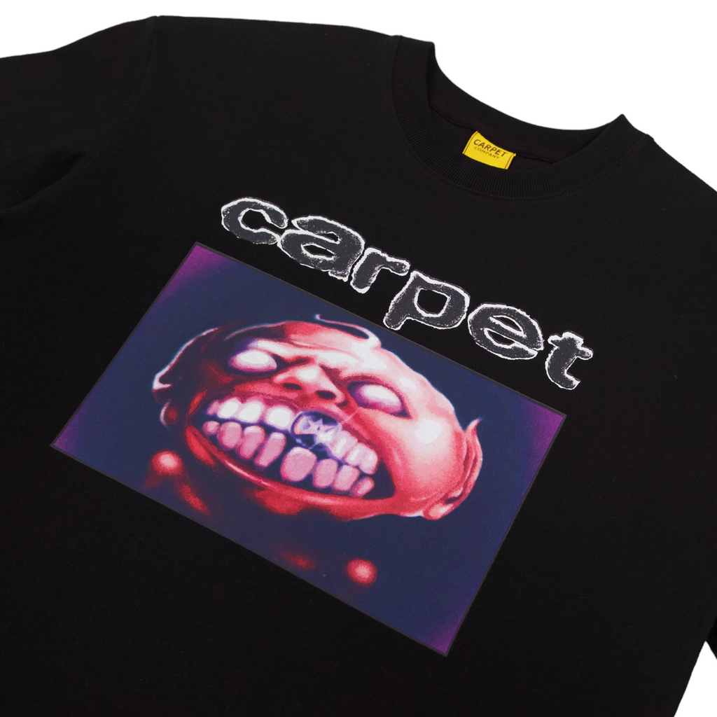 A close up of a black tshirt with the word "carpet" and an image of a character showing its teeth