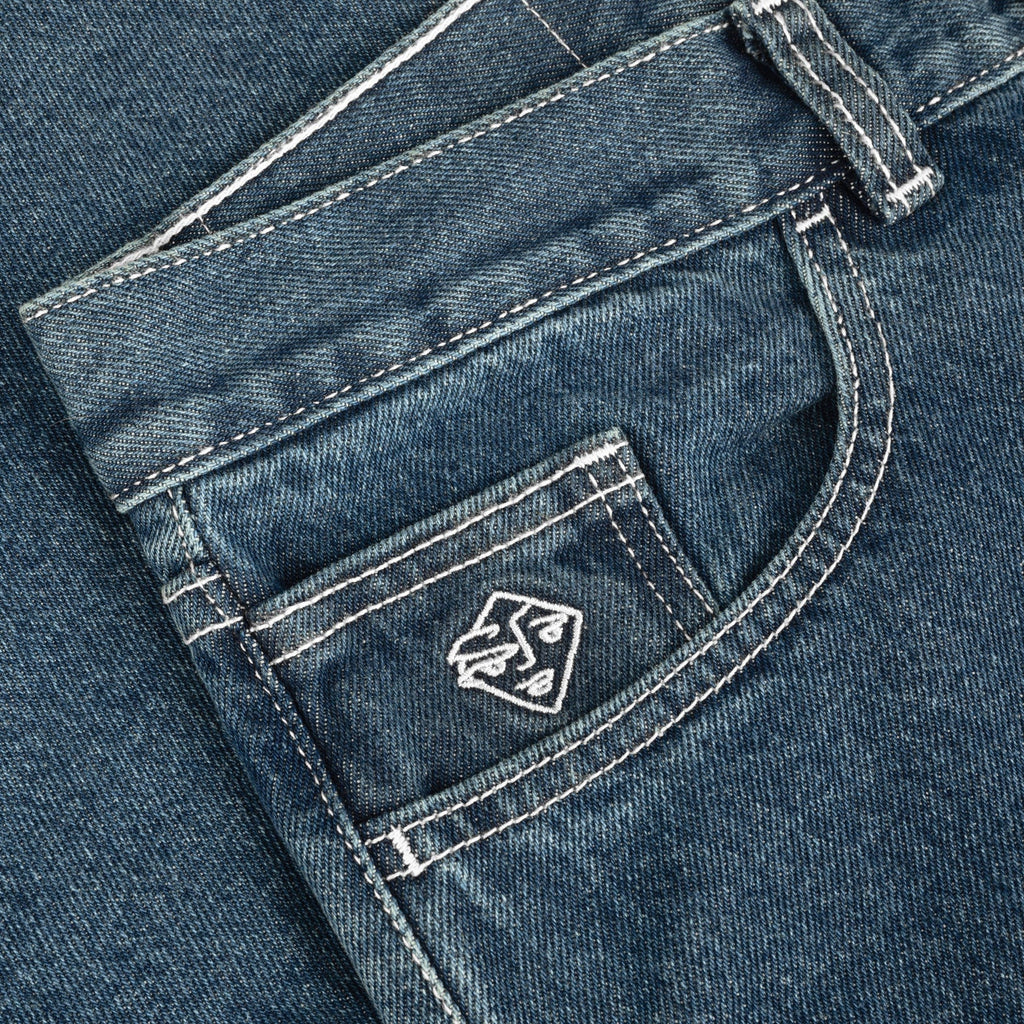 Close-up of the front pocket of POLAR '89! DENIM BLUE WASH jeans, featuring detailed stitching and a small embroidered logo, showcasing their regular fit design.