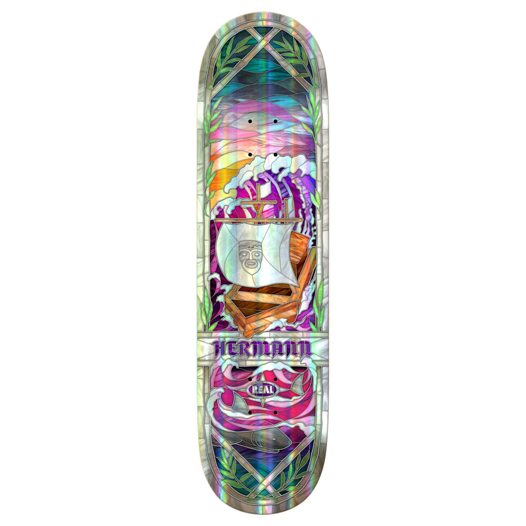 The REAL HERMANN CATHEDRAL HOLOGRAPHIC 8.38" deck by REAL features a vibrant stylized ship with a face, surrounded by leaves and geometric shapes, plus holographic rainbow foil accents and “HERMANN” and “REAL” printed below.