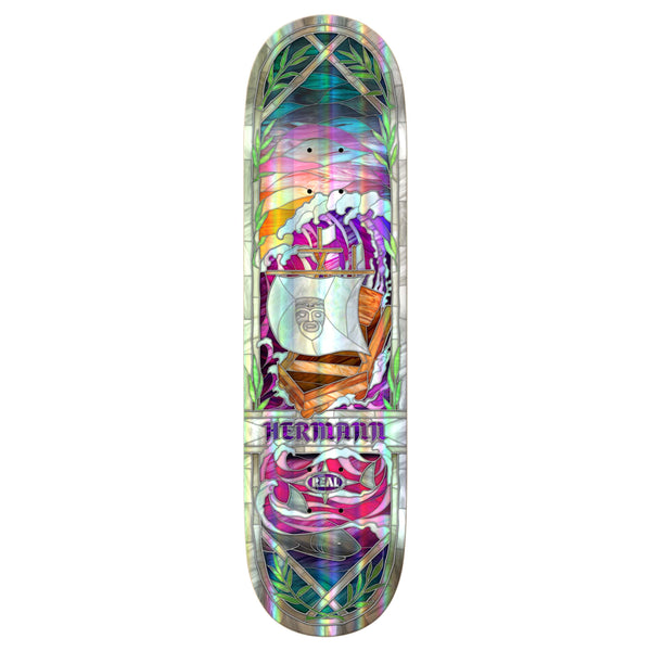 The REAL HERMANN CATHEDRAL HOLOGRAPHIC 8.38" deck by REAL features a vibrant stylized ship with a face, surrounded by leaves and geometric shapes, plus holographic rainbow foil accents and “HERMANN” and “REAL” printed below.