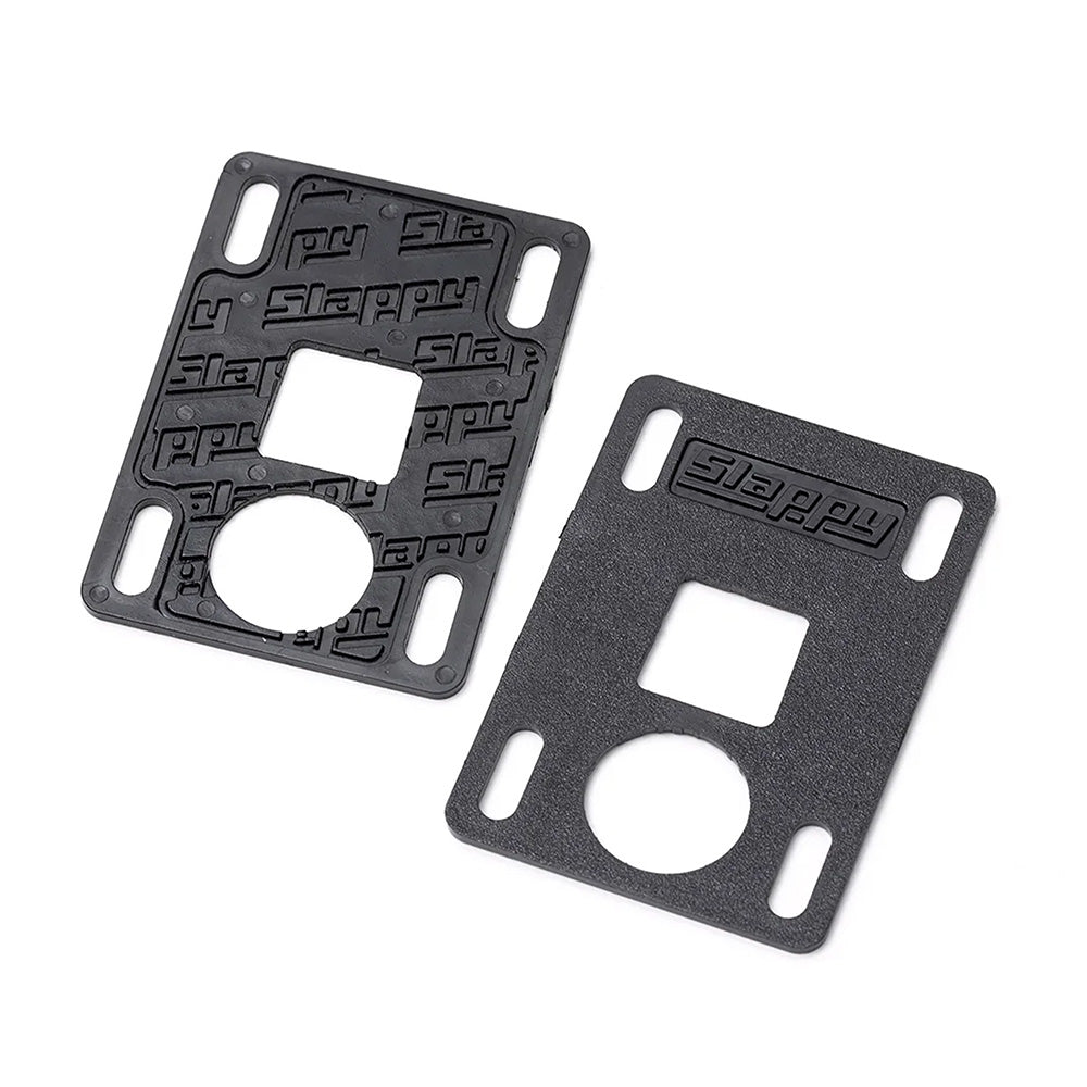 A pair of black SLAPPY TRUCKS SLAPPY SLABS 1MM LOW RISERS with slotted holes, one textured and one smooth, both featuring embossed "Slappy" branding for style and functionality.
