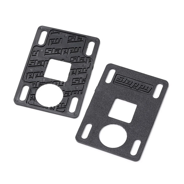 A pair of black SLAPPY TRUCKS SLAPPY SLABS 1MM LOW RISERS with slotted holes, one textured and one smooth, both featuring embossed "Slappy" branding for style and functionality.