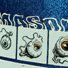 The REAL MASON 4TH WALL GLITTER by REAL features illustrated eyeballs with tendrils against a glittery blue backdrop, evoking the edgy appeal of a skateboard graphic, with partially visible white lettering.