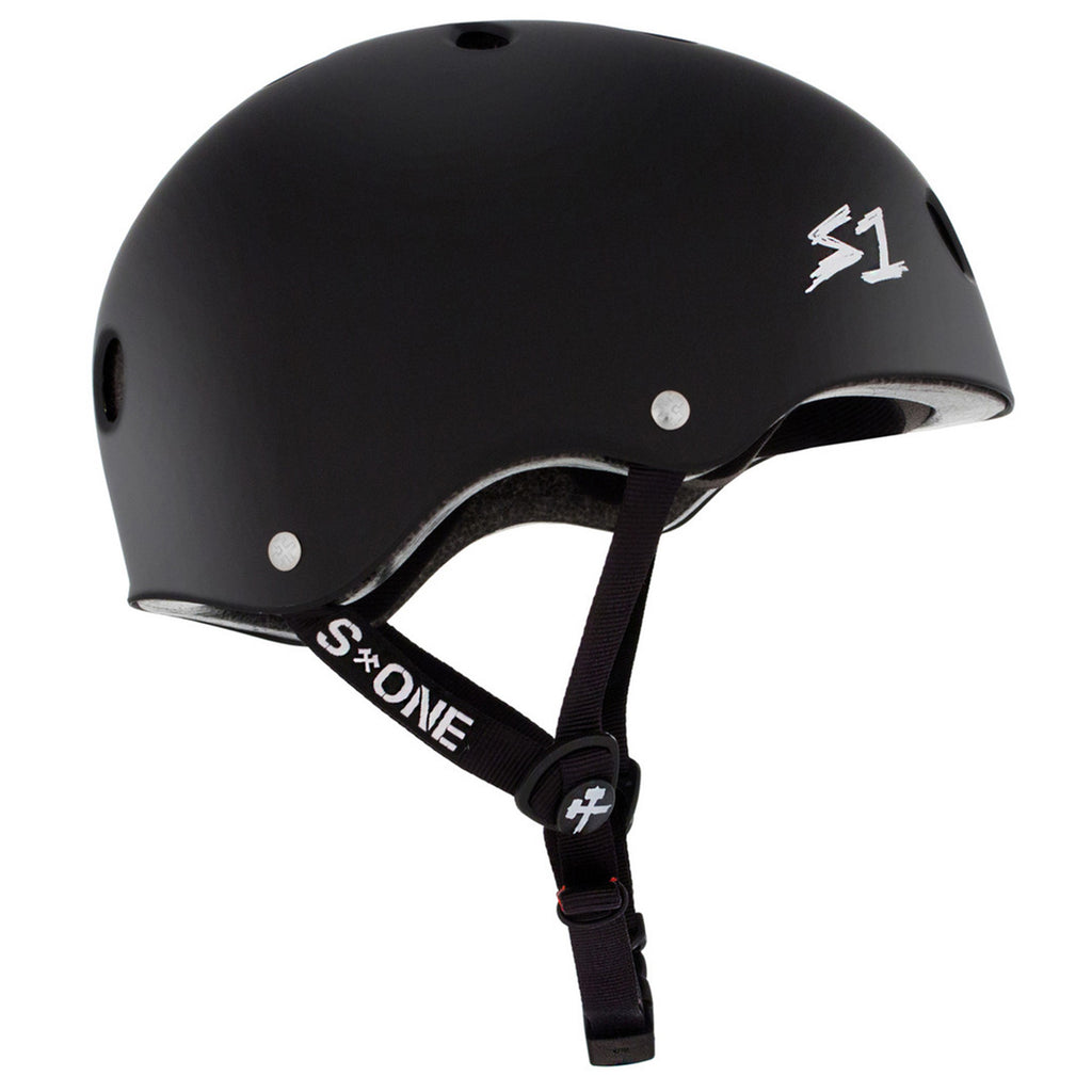 The side view of a black helmet with black straps and a white S1 logo.