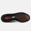The image shows the black and brown rubber outsole of the NB NUMERIC "GREY DAYS" REYNOLDS 933 in dark grey and white, featuring the brand's logo and a red ABZORB label near the heel to emphasize its heritage design.