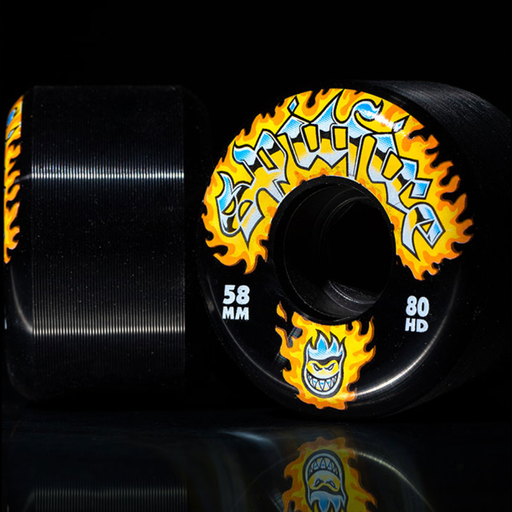 SPITFIRE 80HD CHROME VENOM CONICAL FULL 58MM skateboard wheels in black feature yellow flames, blue accents, "CONICAL FULL 58MM" text, and a grinning face logo—ideal for skaters who SKATE LIKE A GIRL.
