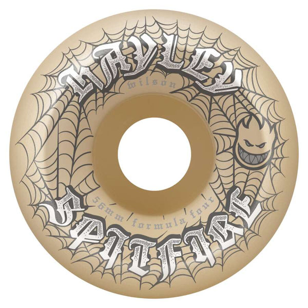 The SPITFIRE F4 HAYLEY WEBBED CONICAL FULL 99D 56MM skateboard wheel features a tan color, black spiderweb design, "SPITFIRE" and "HAYLEY" text, Formula Four conical full 99D construction, and a small flame face logo.