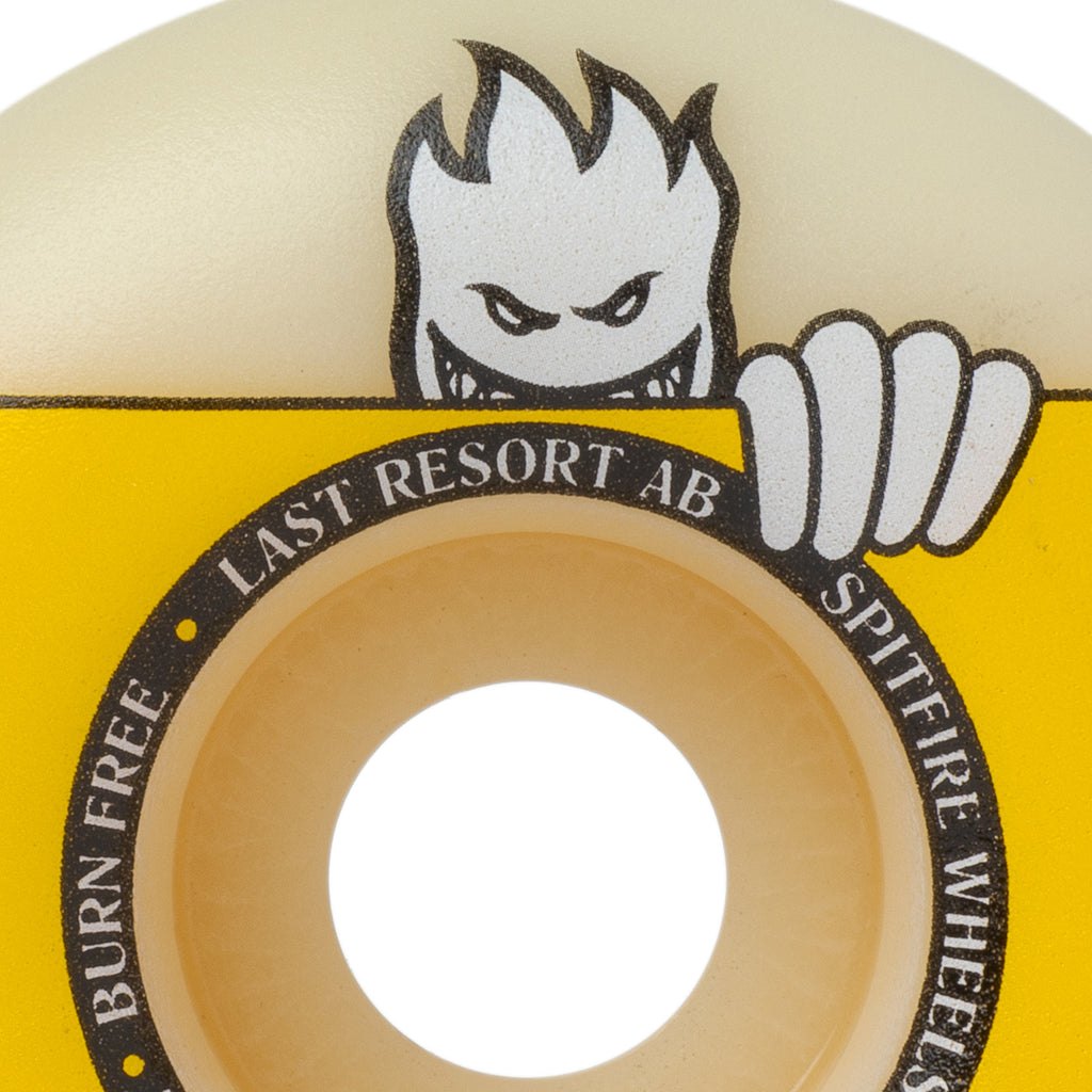 A yellow SPITFIRE skateboard wheel with a face on it featuring SPITFIRE.