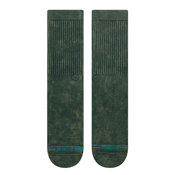 The STANCE SOCKS ICON DYED PINE LARGE by STANCE are dark green crew socks in a soft cotton blend, featuring a ribbed upper section and a blue-striped design with text near the toes, shown side by side on a white background.