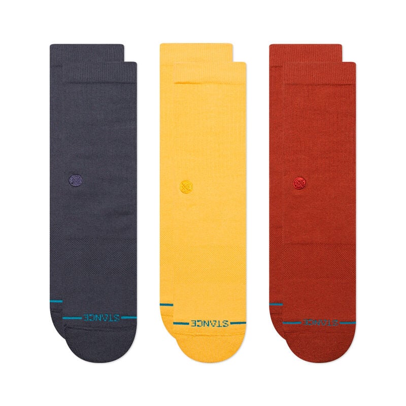 Three pairs of STANCE socks are laid flat side by side. The STANCE SOCKS ICON 3 PACK NAVY LARGE are solid colors: dark gray, mustard yellow, and rust red, each with a small embroidered logo. Made from a soft cotton blend and designed with arch support, they provide both comfort and style.
