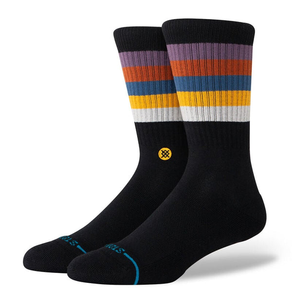 A pair of STANCE SOCKS MALIBOO GRAPE LARGE featuring colorful horizontal stripes in purple, dusty rose, orange, brown, blue, and white near the top on a black background. They are made from a soft cotton blend and displayed against a white background.