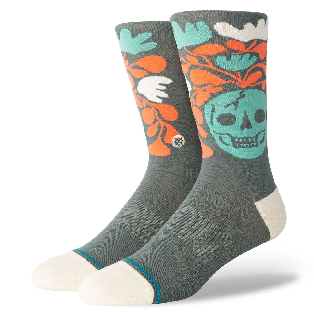 A pair of grey socks with a teal skull and orange vines. 