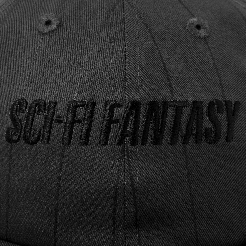 A close up of the black embroidery of the sci-fi logo on the front of the hat.