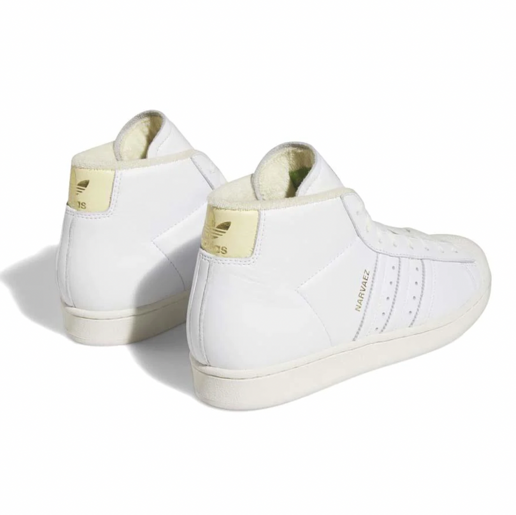 A pair of ADIDAS SAM NARVAEZ PRO MODEL ADV WHITE / EASY YELLOW sneakers with gold detailing.