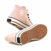 The very bottom brown sole of pink shoes with the converse logo on the outside side.