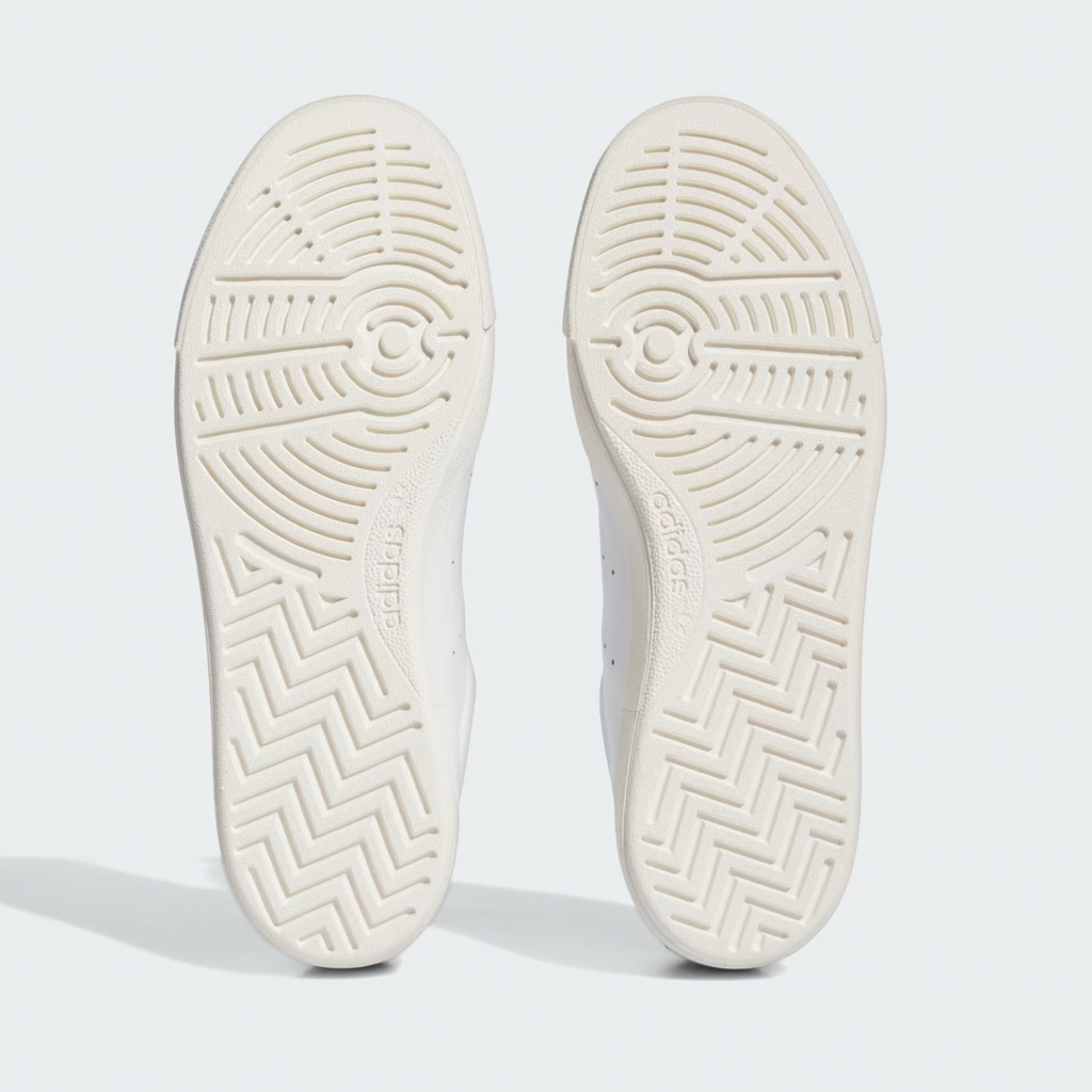 The bottom grip sole of the shoes that are made of white rubber and have the adidas logo.