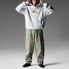 A man wearing baggy Butter Goods Santosuosso Camo Pants.