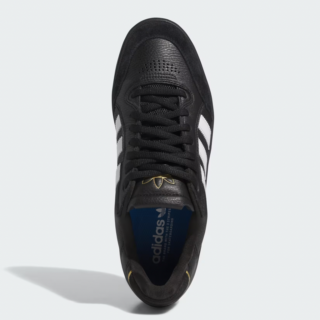 Top view of an Adidas Tyshawn Low Core Black sneaker featuring Cloud White stripes, a blue insole, visible laces, logo details, and Adiprene cushioning designed for skateboarding.