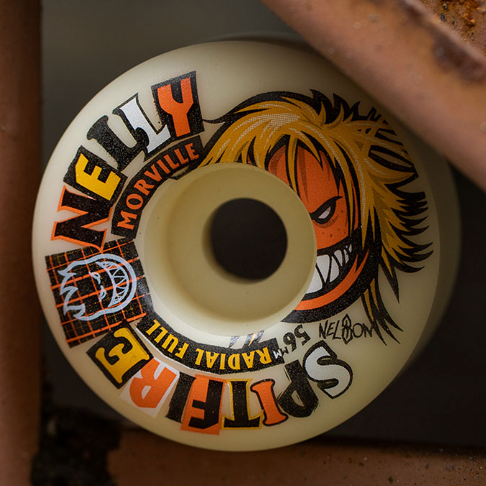 A close-up of a SPITFIRE F4 MORVILLE RADIAL FULL 99D 59MM skateboard wheel by SPITFIRE, featuring "RADIAL FULL 99D," "MORVILLE," and an illustrated face in bold, colorful print.