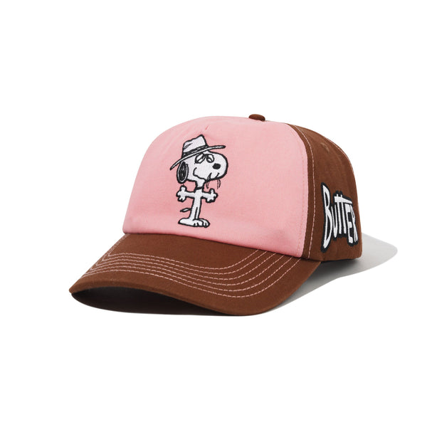 The Butter Goods BUTTER X PEANUTS SPIKE 5 PANEL CAP in brown and light pink is a cotton twill cap featuring an embroidered Snoopy on the front and "Butter" stitched on the side.