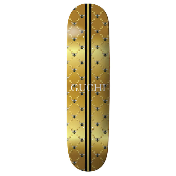A THANK YOU 'GUCHI' BEE GOLD skateboard with the word cufi on it, designed by Danny Hamaguchi.