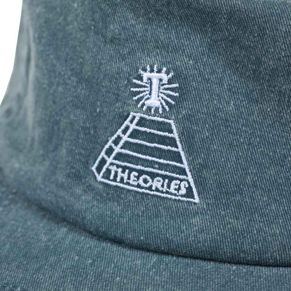 Close-up of a khaki THEORIES SCRIBBLE DENIM STRAPBACK HAT with an embroidered logo featuring a pyramid, a shining eye, and the word "theories.