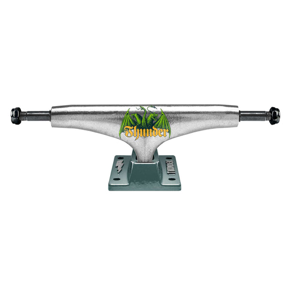 A silver skateboard truck with black bolts, featuring a green flame design and the brand name "Thunder" in yellow on the center. The baseplate is gray with the "Thunder" logo. These trucks come with inverted hollow kingpins for better grind clearance. This product is the THUNDER TRUCKS MEDIEVAL SCRIPT TEAM EDITION 148 (SET OF TWO) by THUNDER.