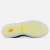 The image shows the bottom view of the NB NUMERIC TIAGO X ROLAND 808 LITE BLACK / ORANGE skate shoe, with a translucent sole, yellow New Balance logo, and a herringbone tread pattern.