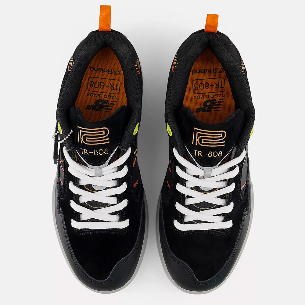 The NB NUMERIC TIAGO X ROLAND 808 LITE BLACK / ORANGE skate shoes feature white laces, orange accents, and “TR-808” and “Roland” logos on the insoles and tongues, inspired by the classic Roland 808 Lite design.