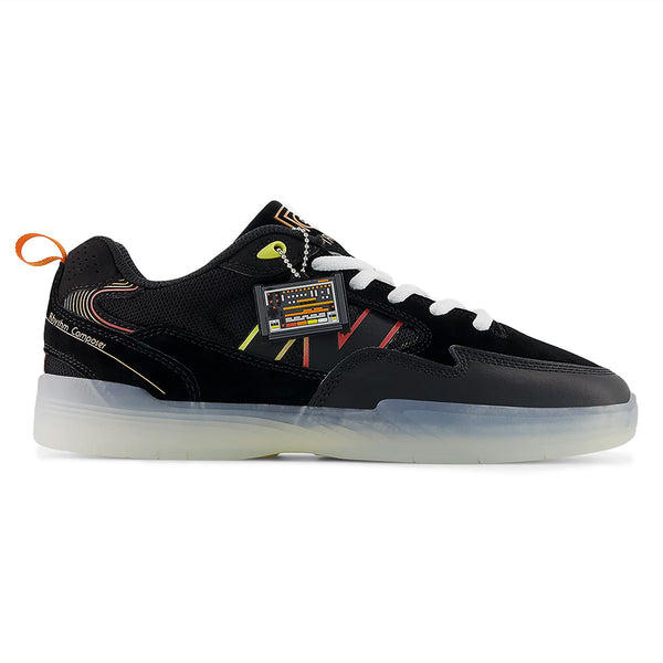 The NB Numeric Tiago x Roland 808 Lite Black/Orange is a black low-top skate shoe with white laces, neon accents, translucent sole, orange heel tab, and side keychain—styled after the classic NB Numeric Tiago.