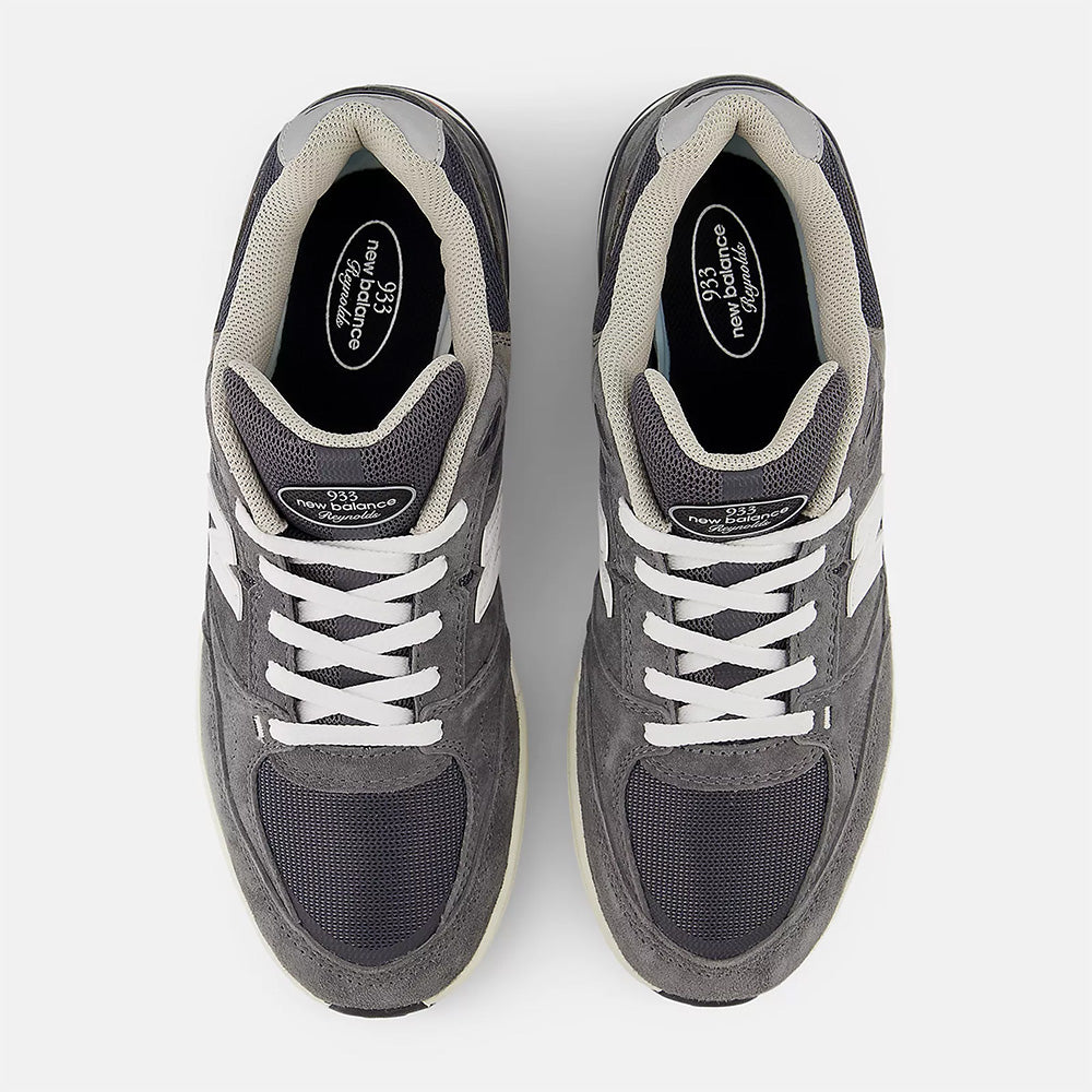 A pair of NB NUMERIC "GREY DAYS" REYNOLDS 933 sneakers in dark grey and white, viewed from above on a plain light background, showcasing heritage design and ABZORB midsole.