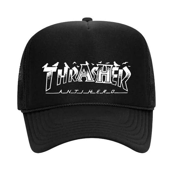 Black mesh trucker hat with the word "Thrasher" and "Anti-Hero" printed in stylized white text on the front, featuring a convenient snapback closure for an adjustable fit. The THRASHER x ANTI HERO PIGEON MAG TRUCKER HAT BLACK by THRASHER combines style and functionality effortlessly.