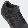A pair of black and gold ADIDAS TYSHAWN CARBON / CORE BLACK / PRELOVED BROWN shoes.