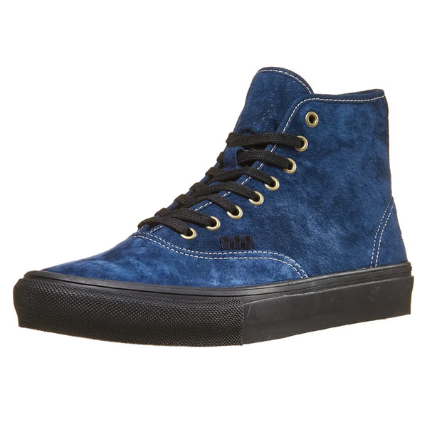 The other side of a blue suede shoe with a dark blue checkered tag and gold eyelets.