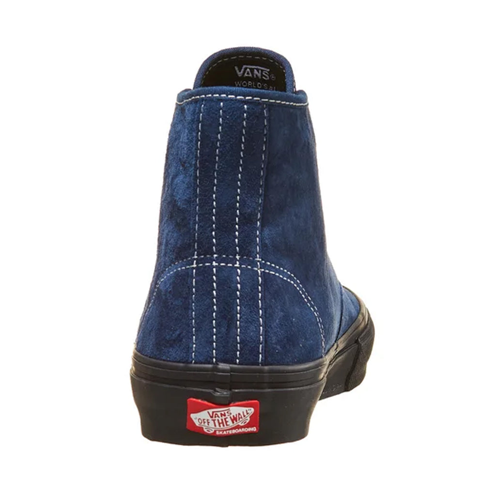 The back of a blue suede shoe with white stitching and the red vans logo on the rubber sole.
