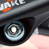 Close-up of a skateboard truck from the VENTURE HOLLOWS "WIDE AWAKE" 5.6 set, featuring a visible bolt and partial logo reading "WAKE." The polished hanger is equipped with 90D bushings for superior performance, securely attached to the skateboard deck.