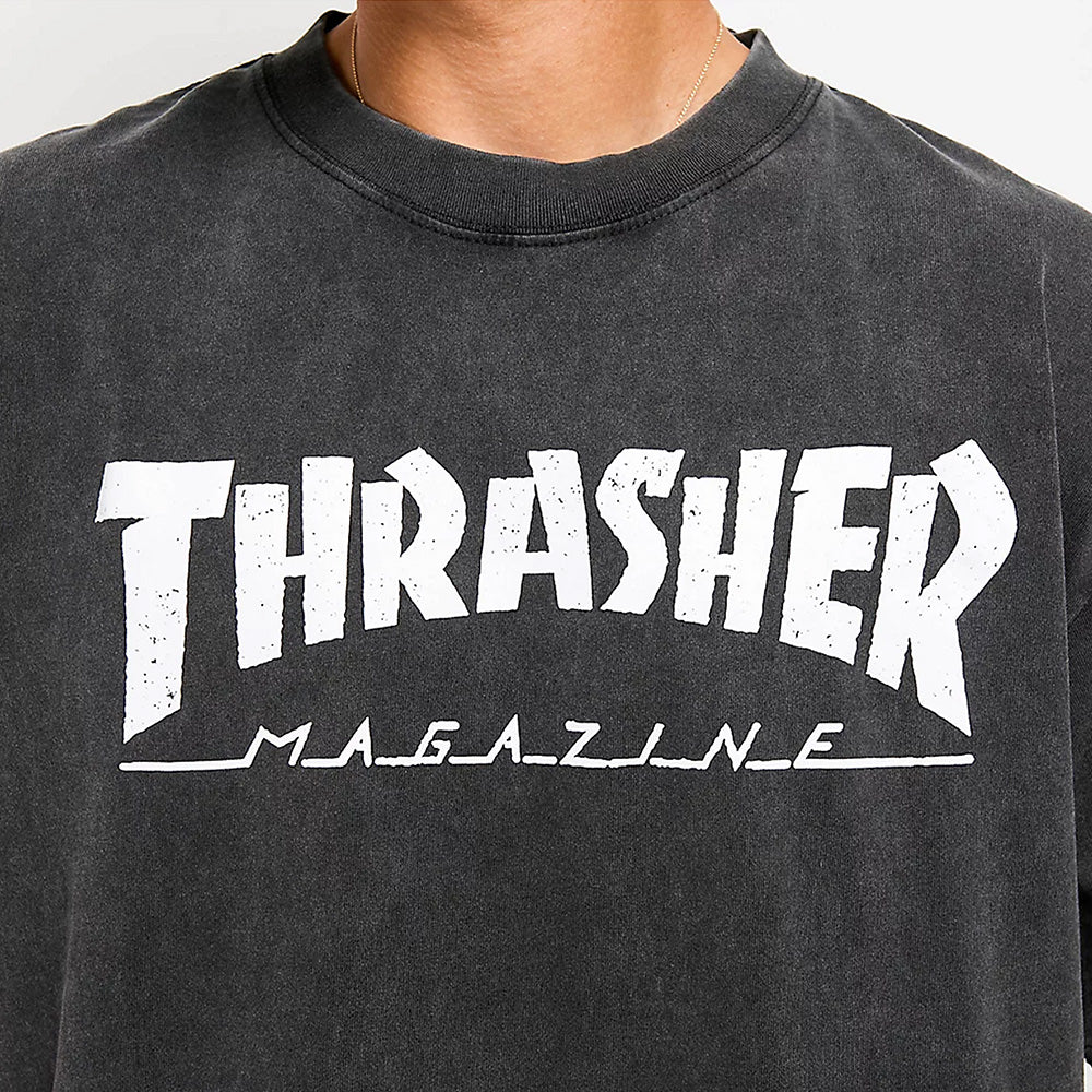 Close-up of a person wearing the THRASHER MAG LOGO VINTAGE TEE BLACK by THRASHER, featuring the iconic white Thrasher Mag Logo printed on the front.