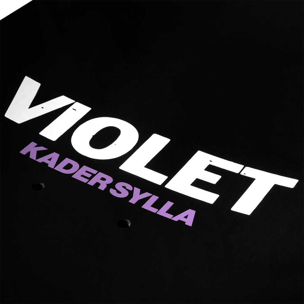 A close up of the black to of the deck that is printed with the words "VIOLET KADER SYLLA".