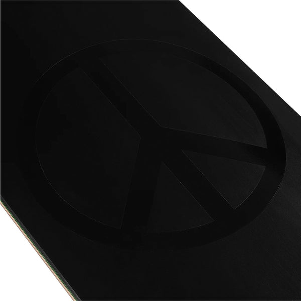 A close-up of a black surface with a subtle, embossed peace symbol, echoing the signature style of the violet VIOLET PEACE (PSALM 91) BLACK/BLACK skateboard.