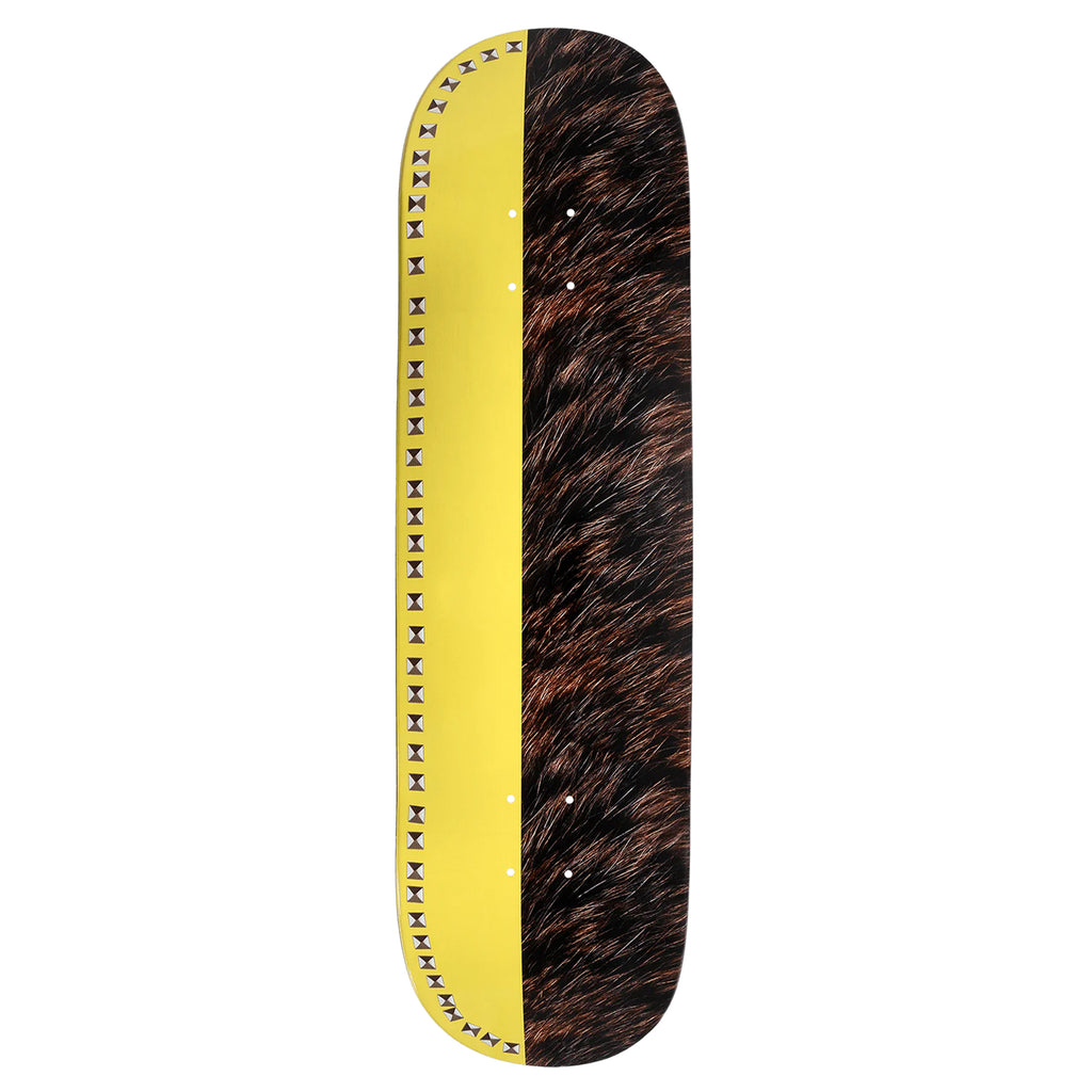 The VIOLET STUDDED BANANA BEAR skateboard deck by violet showcases a striking yellow stripe and a fur-like pattern, accented with small black triangles along the edges. Its design echoes the dynamic energy and artistic flair of Violet Kader's creations, reminiscent of modern artwork.