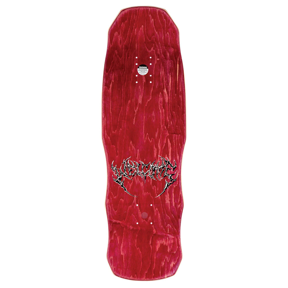 A red WELCOME TORMENT ON DARK LORD skateboard deck with a wood grain finish and a central stylized logo. The wide, irregular shape features unique rear cutouts, staying true to WELCOME’s distinct design approach.