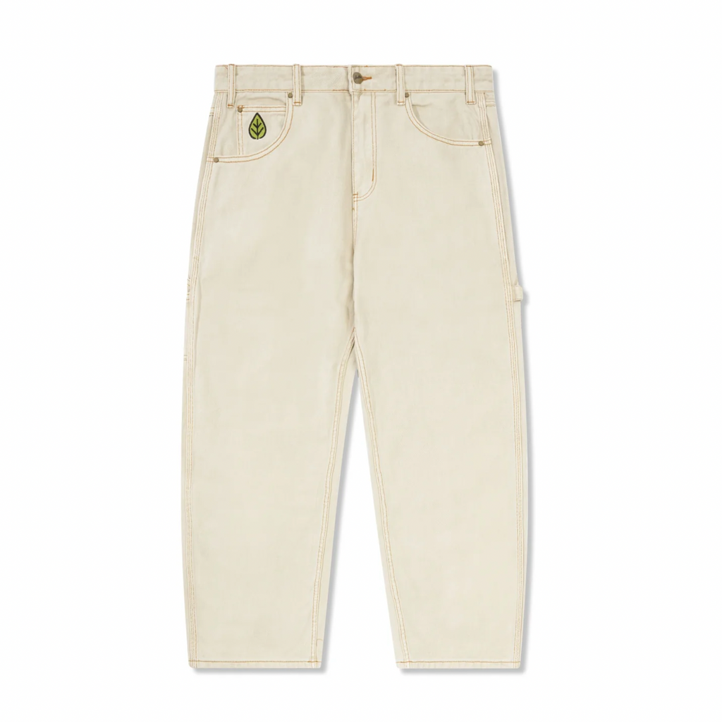 The BUTTER GOODS WEATHERGEAR HEAVY WEIGHT DENIM JEANS in Washed Khaki from Butter Goods feature a relaxed fit with visible stitching and an embroidered green leaf on the right pocket, reminiscent of classic denim jeans.