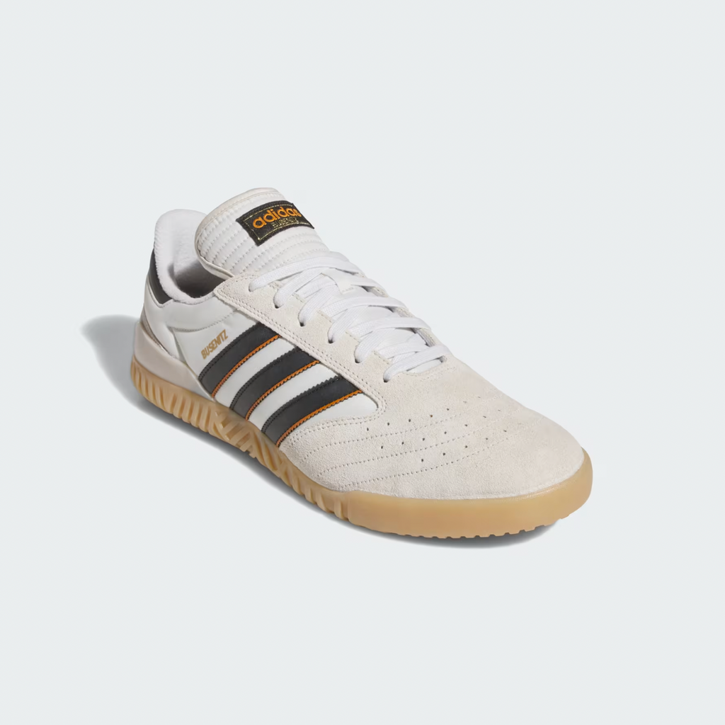 A beige adidas Busenitz Indoor Super sneaker with black stripes, white laces, a gum sole, and "Busenitz" branding on the side features a durable leather upper, displayed on a light background.