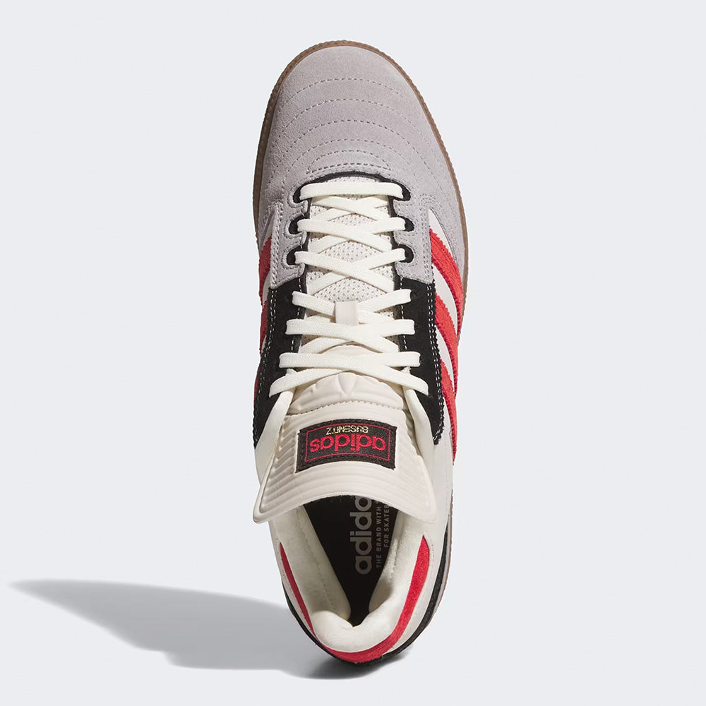 Top view of the ADIDAS BUSENITZ BLISS / BETTER SCARLET / GUM skate shoe featuring a gray toe, red stripes, black accents, white laces, a brown gum cupsole, and an Adidas logo on the tongue.