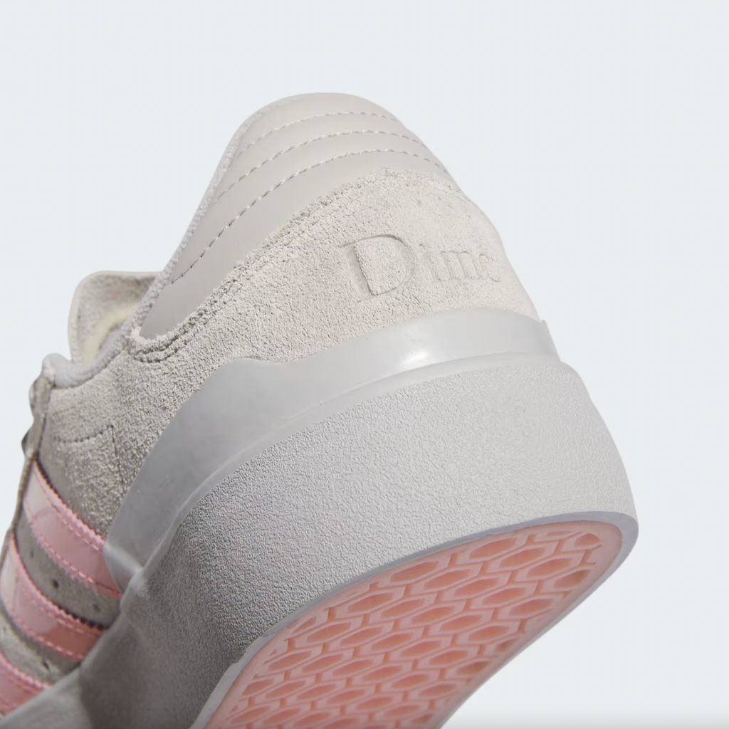 A white and pink ADIDAS X DIME BUSENITZ VULC 2.0 shoe with a pink sole.