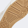 Close-up of the ADIDAS NORA ALUMINUM / WHITE / GOLD sneaker’s sole, featuring a tan rubber outsole with circular and linear treads plus Adidas logo—designed for durability and inspired by Nora Vasconcellos.