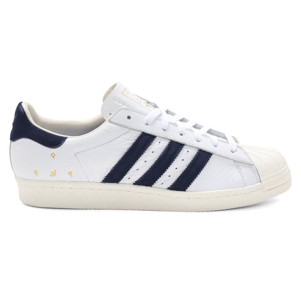 ADIDAS X POP TRADING CO. SUPERSTAR ADV sneakers in white and navy.